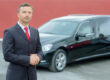 Hearse sales with a man in suit standing next to a hearse