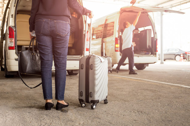 Woman waiting to be picked up by sprinter van shuttle service.