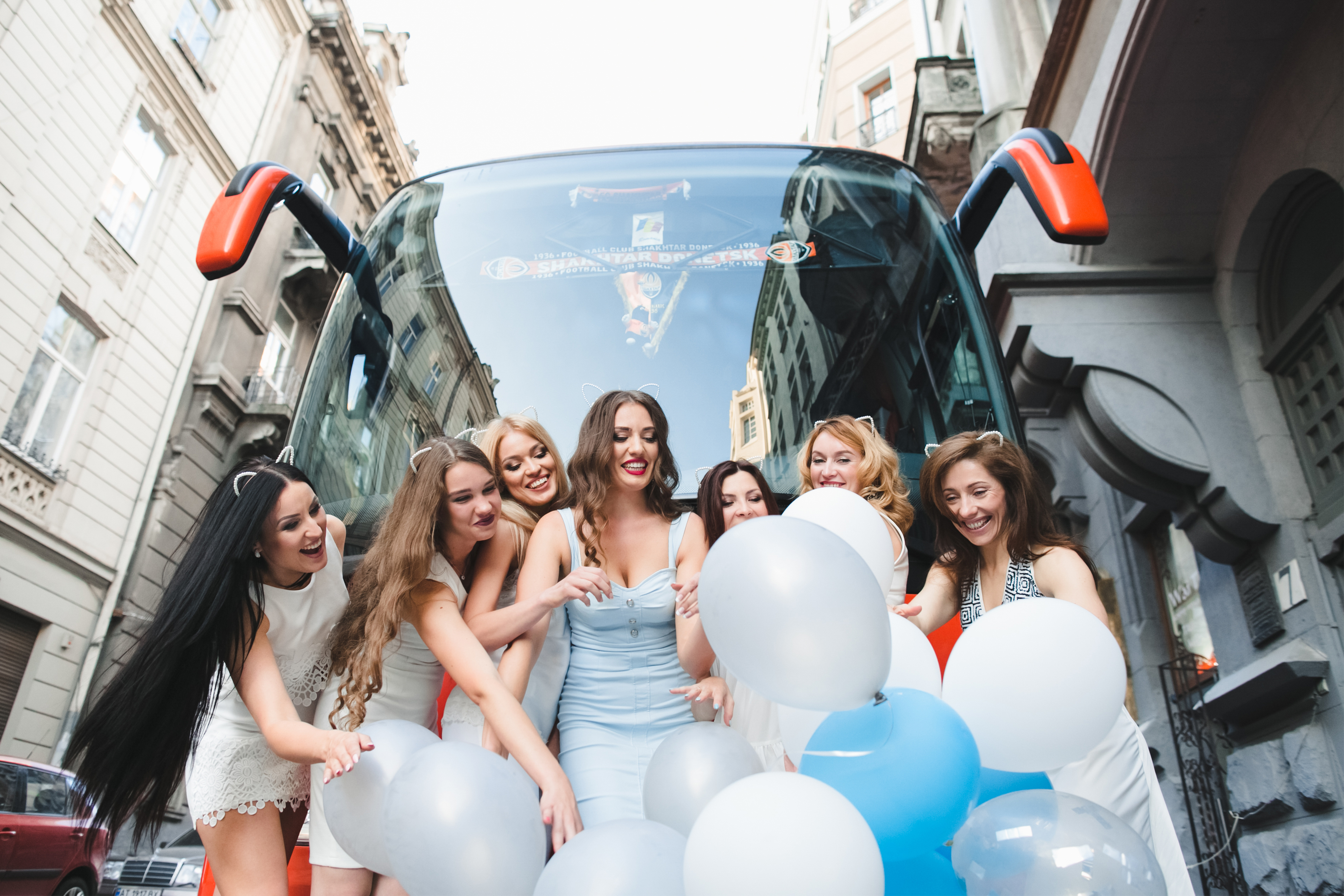 Bridal party in front of a limo bus