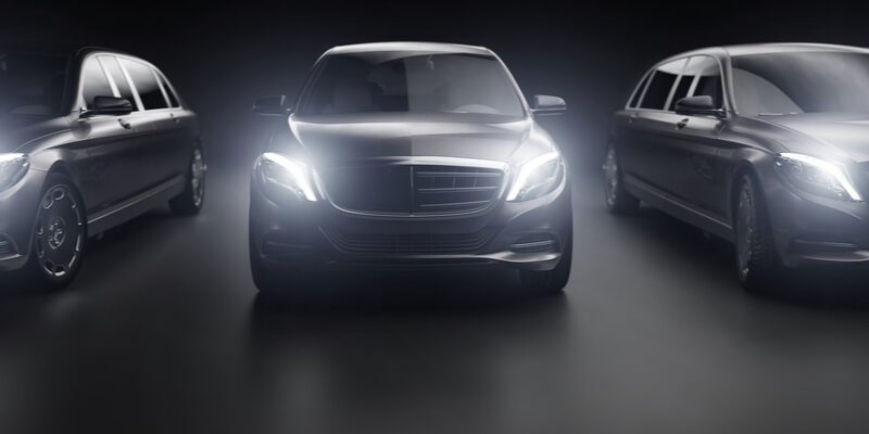 Fleet of luxury vehicles with their headlights on