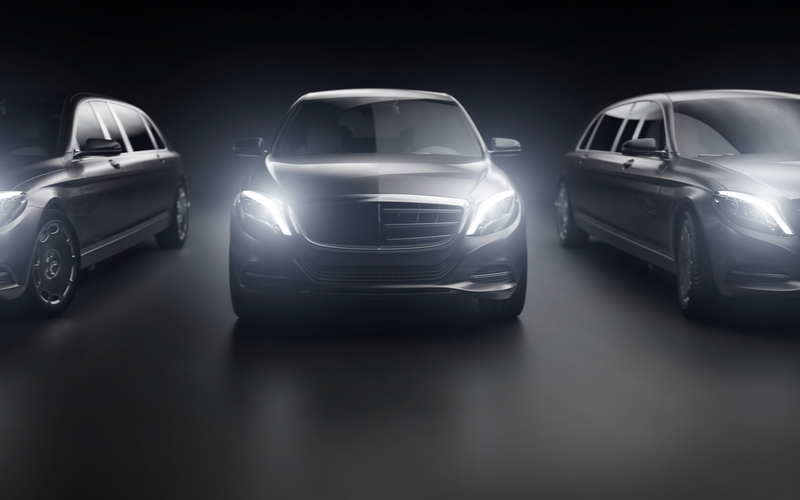 luxury vehicle fleet with headlights pointing at camera Fleet of luxury vehicles with their headlights on