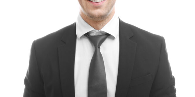 Young,Chauffeur,Standing,On,White,Background Chauffeur wearing a black tie and white shirt