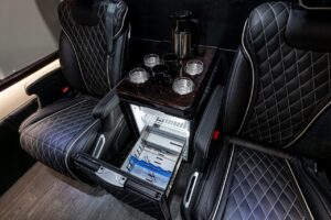 Black leather seats and mini fridge inside a 2022 Mercedes Benz Executive Coach CEO Sprinter Diplomat