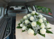 Inside of a Funeral Car with Flowers on a Wood Casket