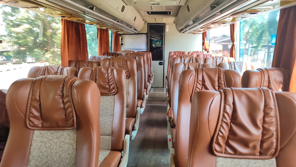 Luxury coach bus interior with brown leather seats and wide windows