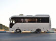 Coach bus parked on the side of the road with mountains in the background