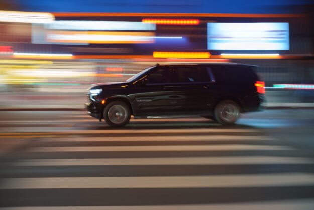 Fast moving black luxury SUV limousine