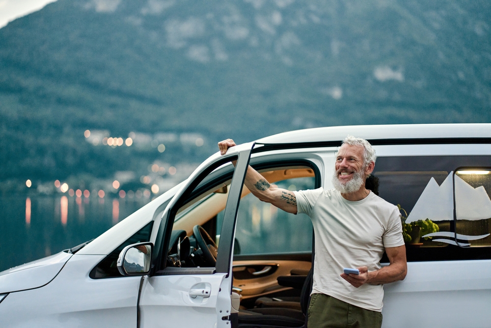 Man enjoying van life with mountains in the background