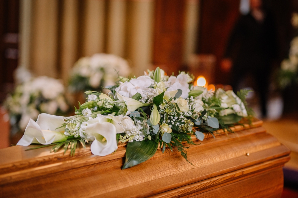  A coffin decorated with flowers and candles 