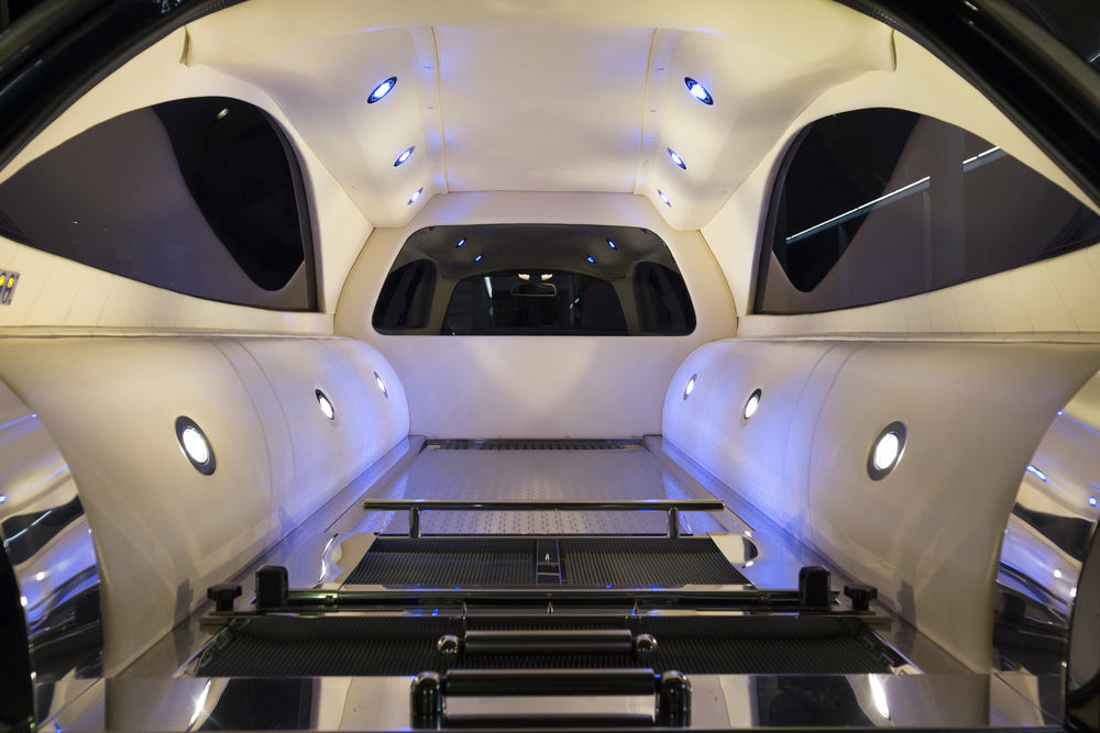 Interior of a modern funeral hearse with illuminated ceiling lights and polished casket compartment